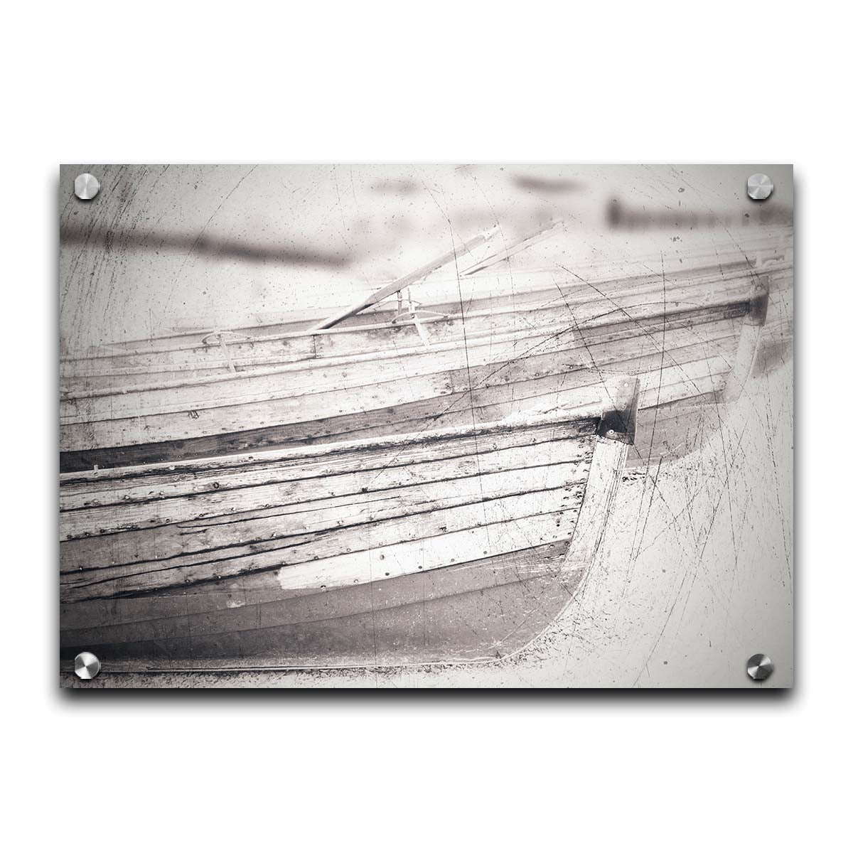 A grayscale photo of two rowboats on the sand. It is overlayed with a scratchy weathered texture. Printed on acrylic.