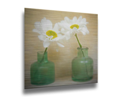 A photo of two white flowers in green glass jars, sitting against one another against a tan backdrop. Printed on metal.