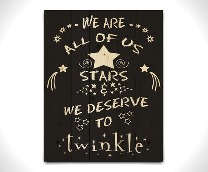 A typography design reading "We are all of us stars and we deserve to twinkle" in white on a black background. Printed on a wood pallet.