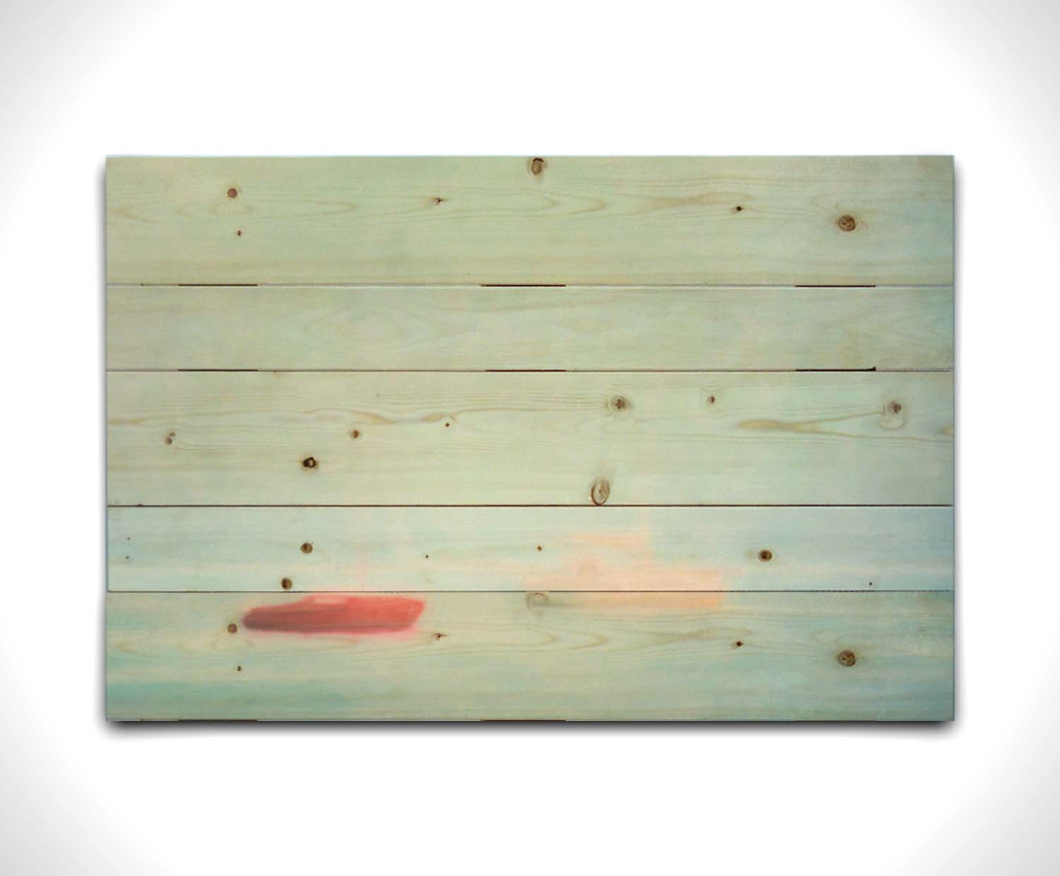 A photo of a small red boat and a small white and yellow boat floating at sea. The photo is edited to have a soft, blurry quality which blends the sky and sea together on the horizon. Printed on a wood pallet.