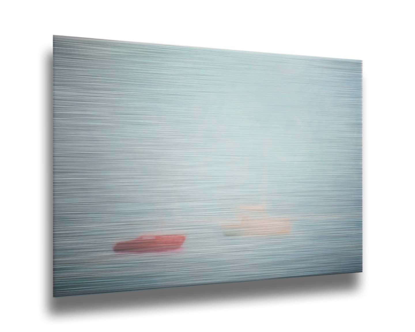 A photo of a small red boat and a small white and yellow boat floating at sea. The photo is edited to have a soft, blurry quality which blends the sky and sea together on the horizon. Printed on metal.