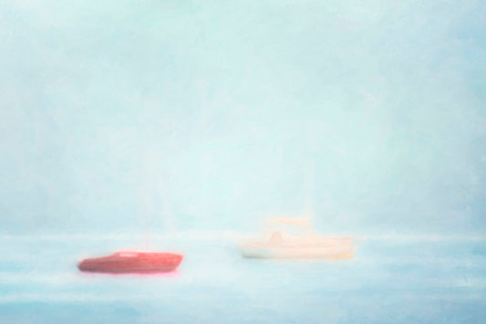 A photo of a small red boat and a small white and yellow boat floating at sea. The photo is edited to have a soft, blurry quality which blends the sky and sea together on the horizon.