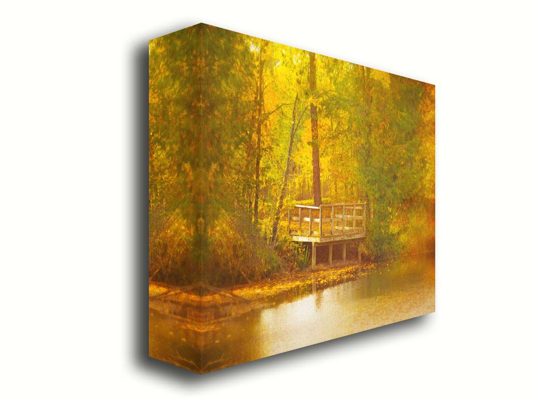 A photo of a small wooden dock, overlooking a forest lake during autumn. Yellow leaves cover the trees and ground, and float atop the water. Printed on canvas.