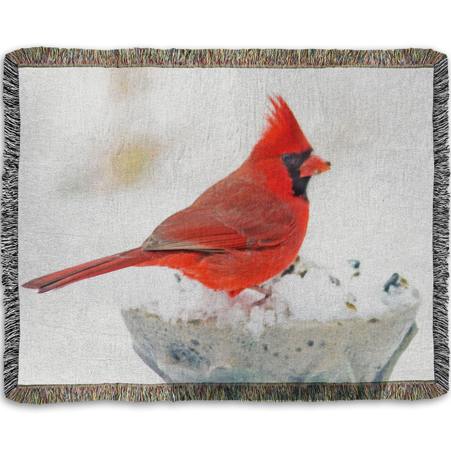 A woven throw blanket printed with a photograph of a red cardinal against white snow.