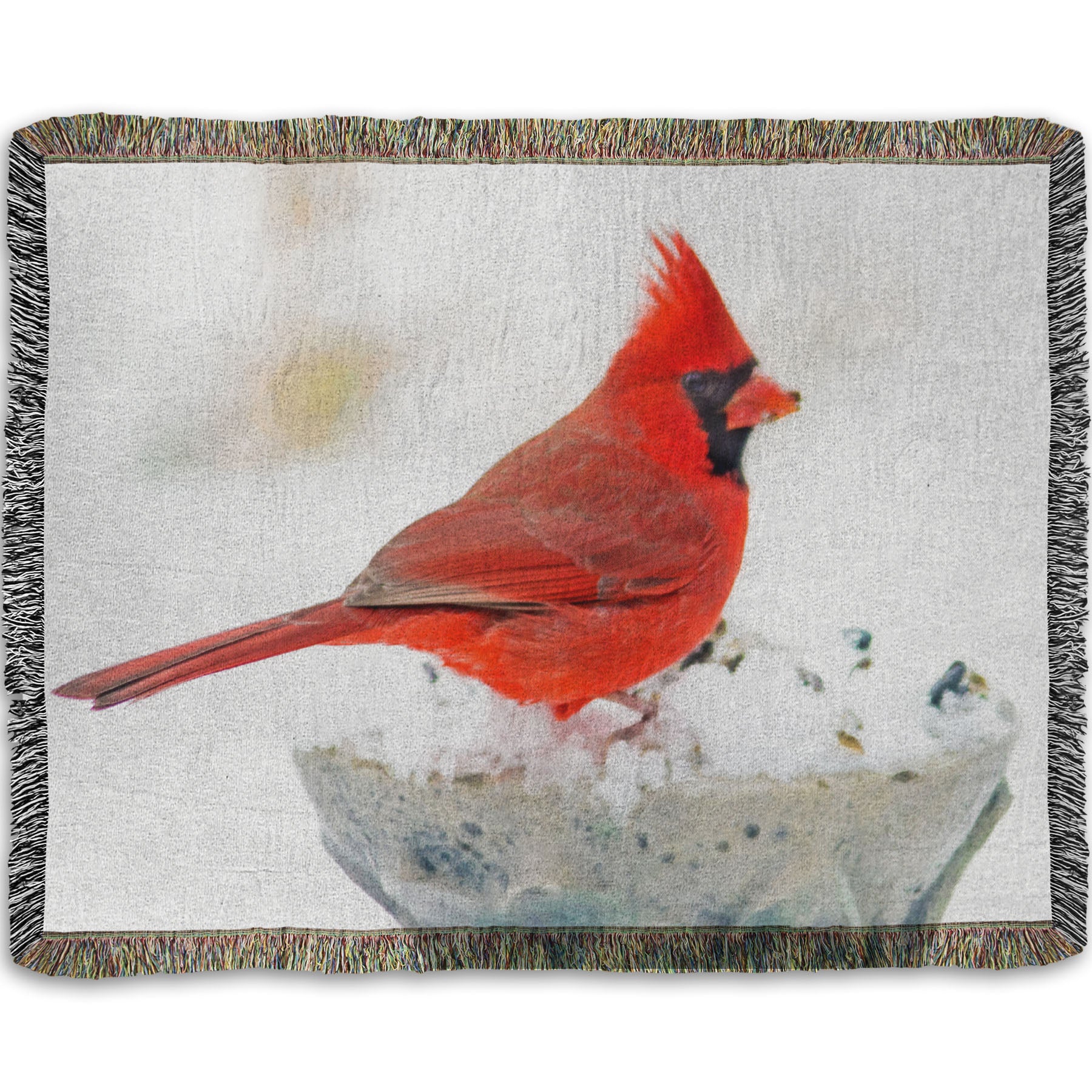 A woven throw blanket printed with a photograph of a red cardinal against white snow.