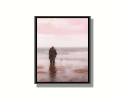 A photograph of a fisherman in oilskins standing in the shallows of the ocean, watching his fishing pole propped up beside him. Printed on canvas in a float frame.