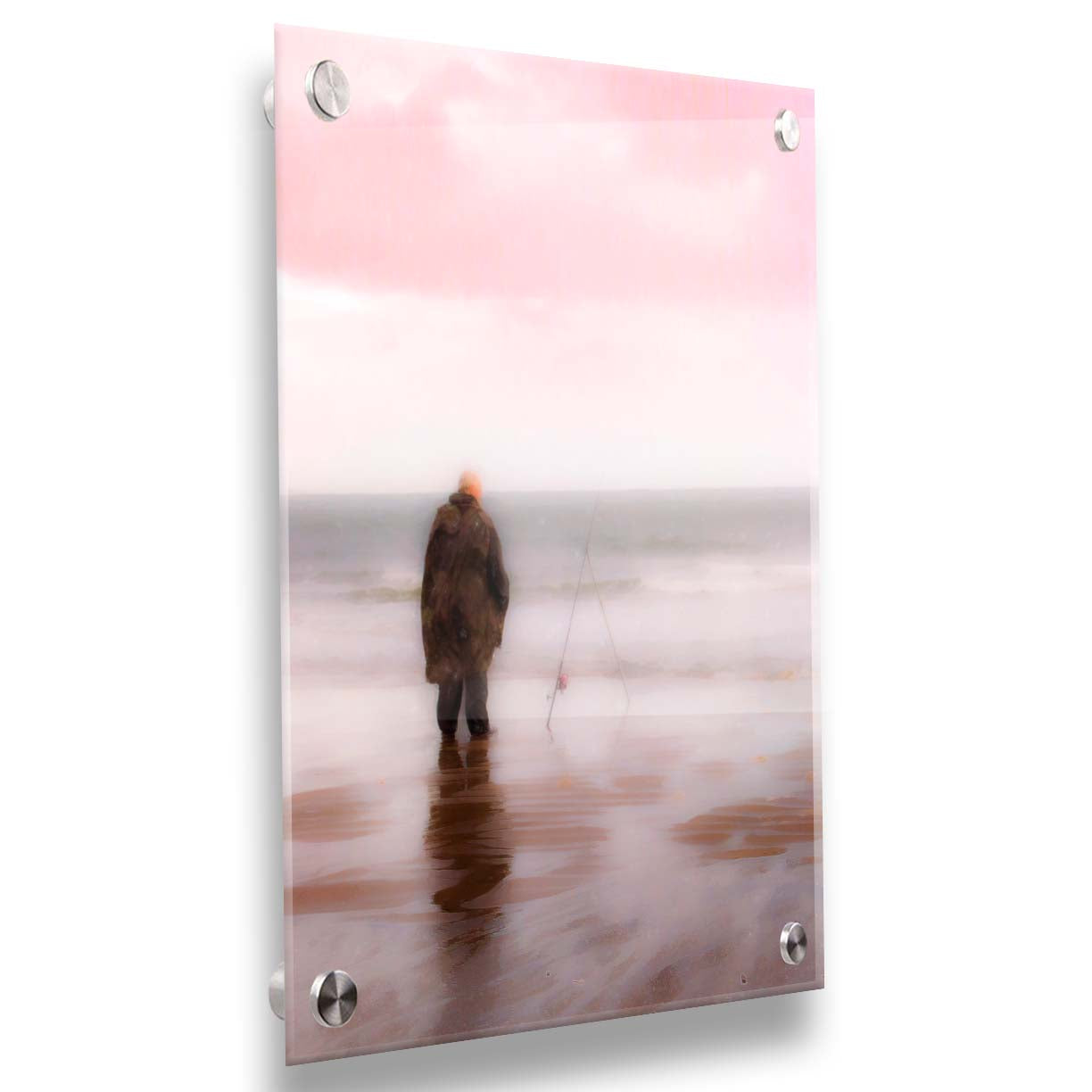 A photograph of a fisherman in oilskins standing in the shallows of the ocean, watching his fishing pole propped up beside him. Printed on acrylic.