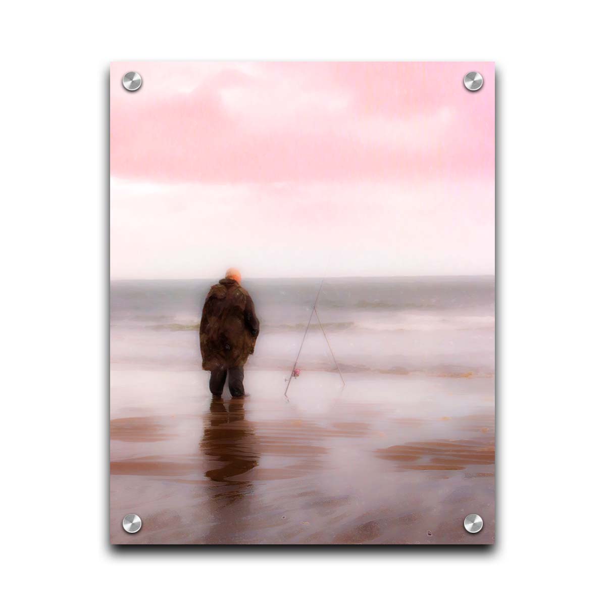 A photograph of a fisherman in oilskins standing in the shallows of the ocean, watching his fishing pole propped up beside him. Printed on acrylic.