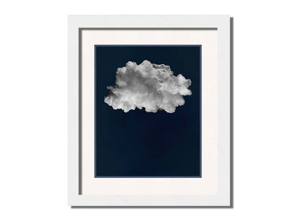 A photo edit of a large, fluffy white cloud against a deep blue background. Printed on paper, matted, and framed.