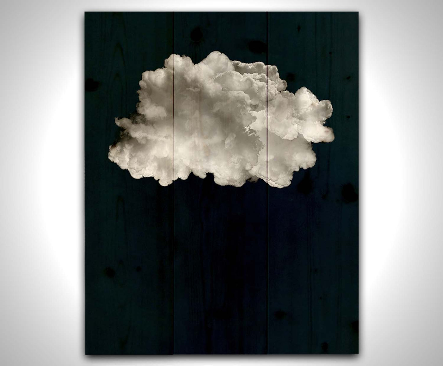 A photo edit of a large, fluffy white cloud against a deep blue background. Printed on a wood pallet.