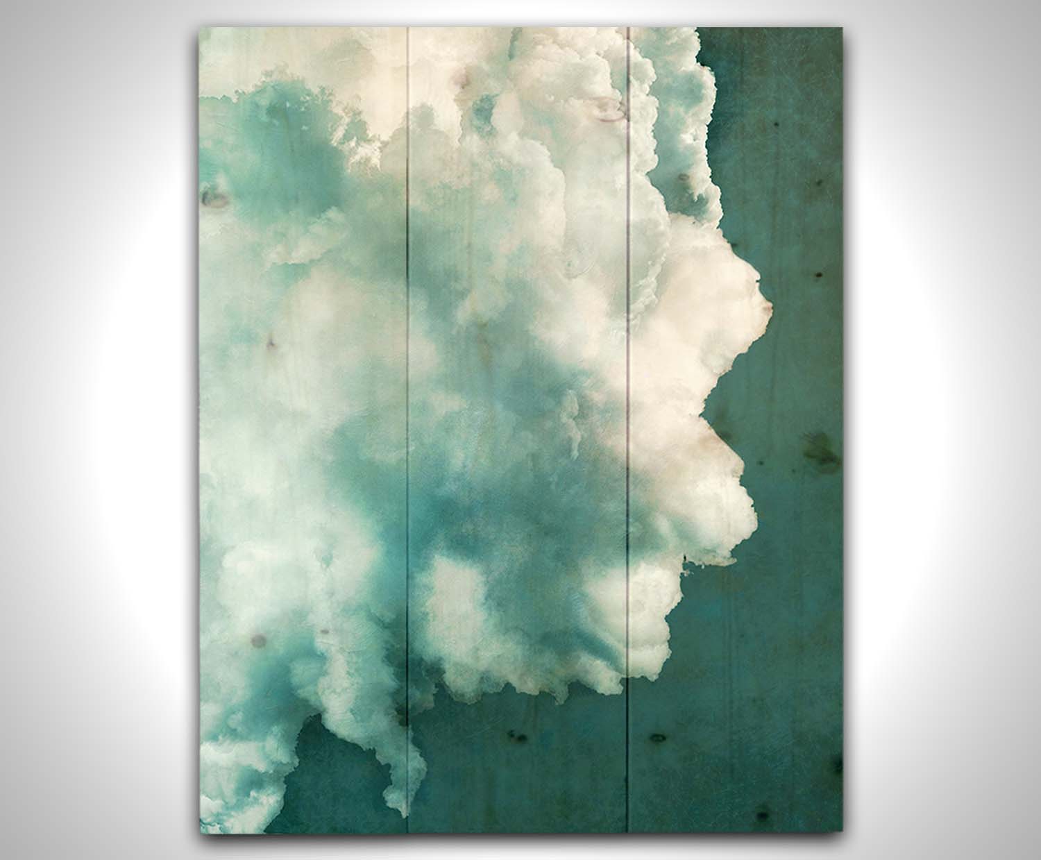 A photograph of a big white cloud with a teal background. Printed on a wood pallet.