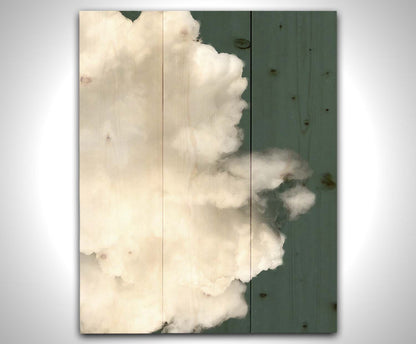 An edited photo of a soft white cloud against a blue background. Printed on a wood pallet.