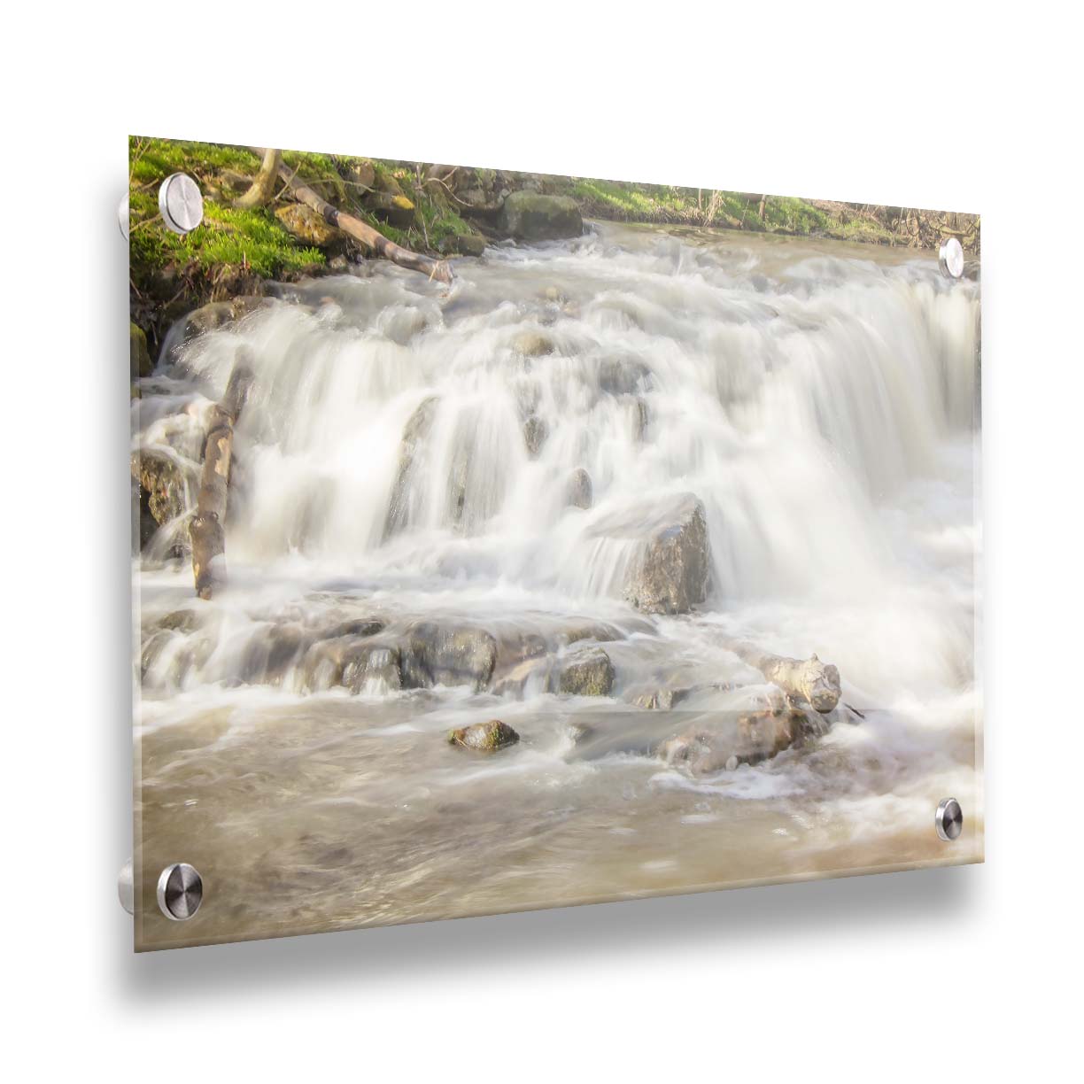 A photograph of a small river waterfall, only a few feet high. The use of a slow shutter speed technique gives the water a soft, gentle appearance. Printed on acrylic.