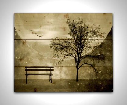 A photo edit of birds flying by a bench and tree in a starry night, with a sepia tone. Printed on a wood pallet.