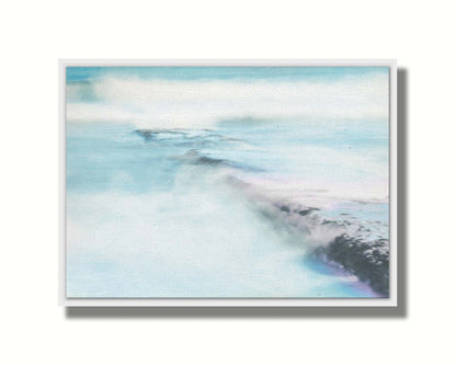 A photograph of a battered jetty being washed over by incoming waves in a cool, white and blue palette. Printed on canvas in a float frame.