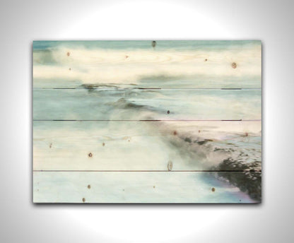 A photograph of a battered jetty being washed over by incoming waves in a cool, white and blue palette. Printed on a wood pallet.