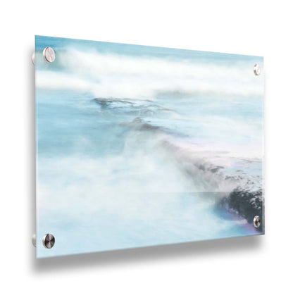 A photograph of a battered jetty being washed over by incoming waves in a cool, white and blue palette. Printed on acrylic.