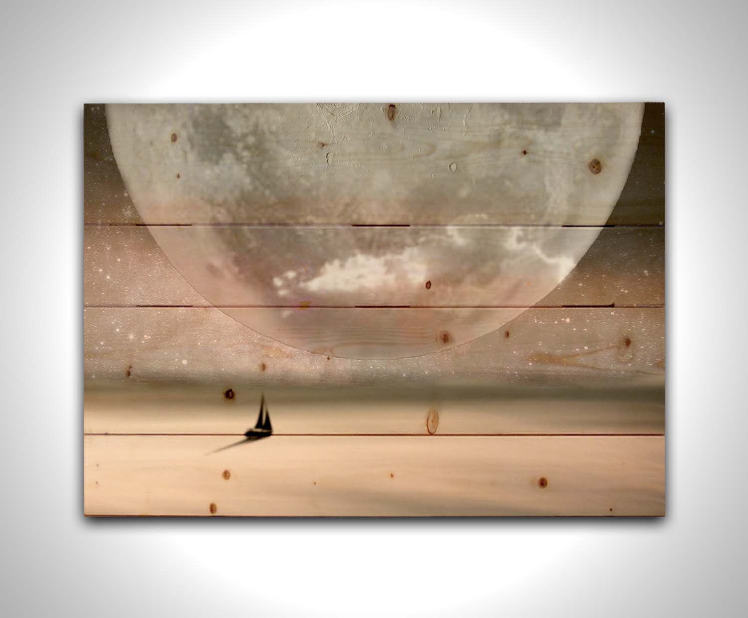 An image in pinks and grays of a sailboat crossing smooth water under a starry sky. The moon is enlarged and takes up most of the sky. Printed on a wood pallet.