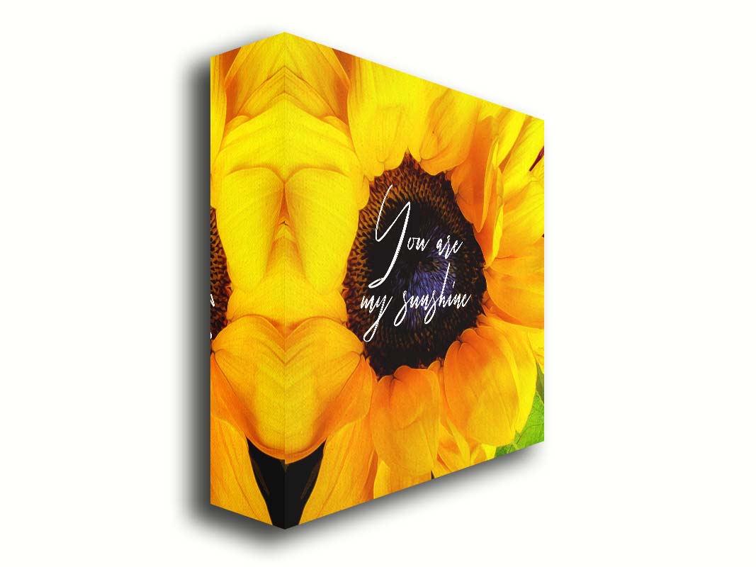 A closeup photo of a bright yellow sunflower, edited in a painterly style and overlaid with the quote "You are my sunshine." Printed on canvas.