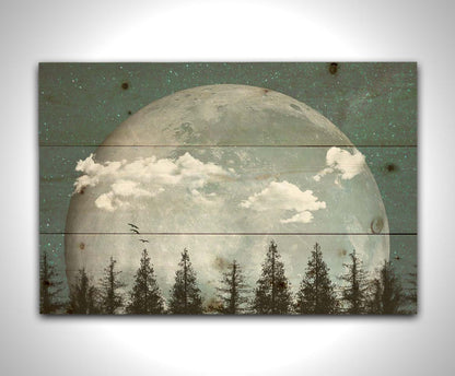 An edited collage of photos depicting an oversized moon over a silhouetted evergreen forest at night. A few clouds and bids pass across the scene. Printed on a wood pallet.