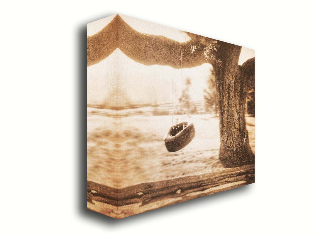 A sepia-tone photograph of a tire swing hanging from a sturdy tree in the daylight. Printed on canvas.