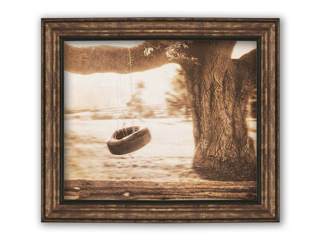 A sepia-tone photograph of a tire swing hanging from a sturdy tree in the daylight. Printed on canvas and framed.