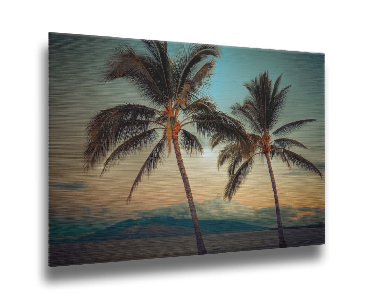 A photo of two palm trees in Maui at sunset, with the sea and cloud-topped mountains in the background. Printed on metal.