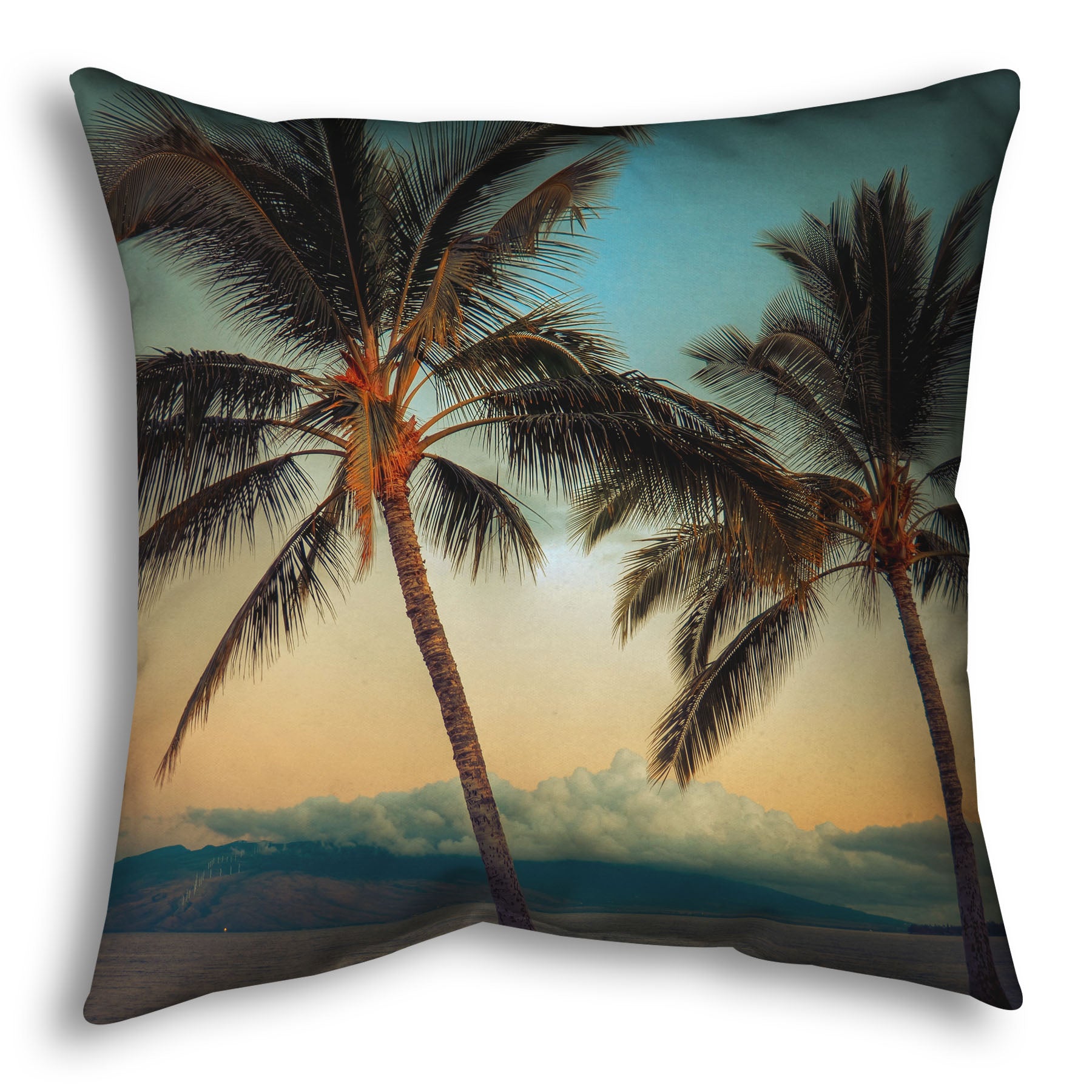 A throw pillow designed with a photo of two palm trees in Maui at sunset, with the sea and cloud-topped mountains in the background.