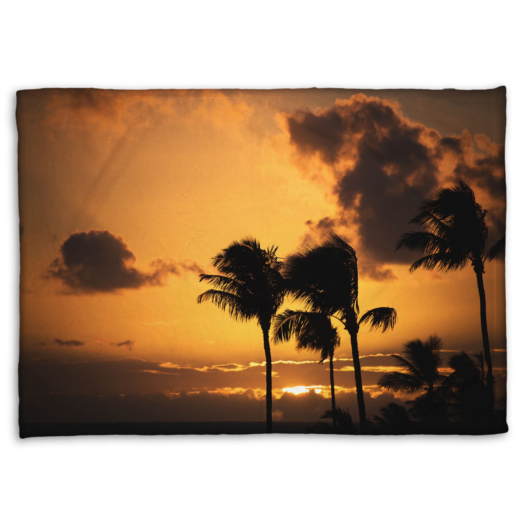 A coral fleece blanket designed with a photo of palm trees in Maui silhouetted by the setting sun, with the sea in the background.