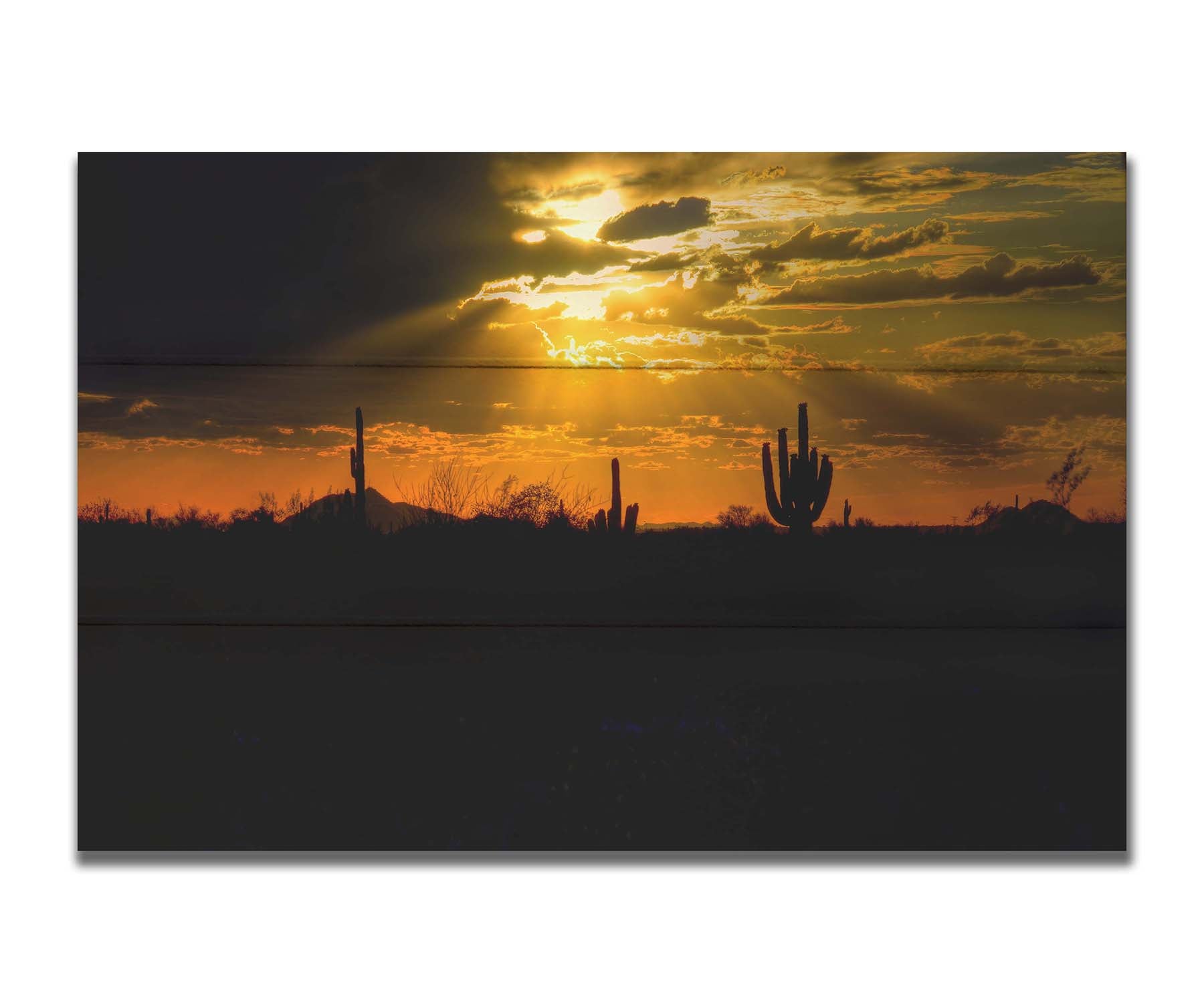 A photo of a sunset over the desert in Arizona, the landscape shadowed in black against the orange and yellow sky. Printed on a box board.