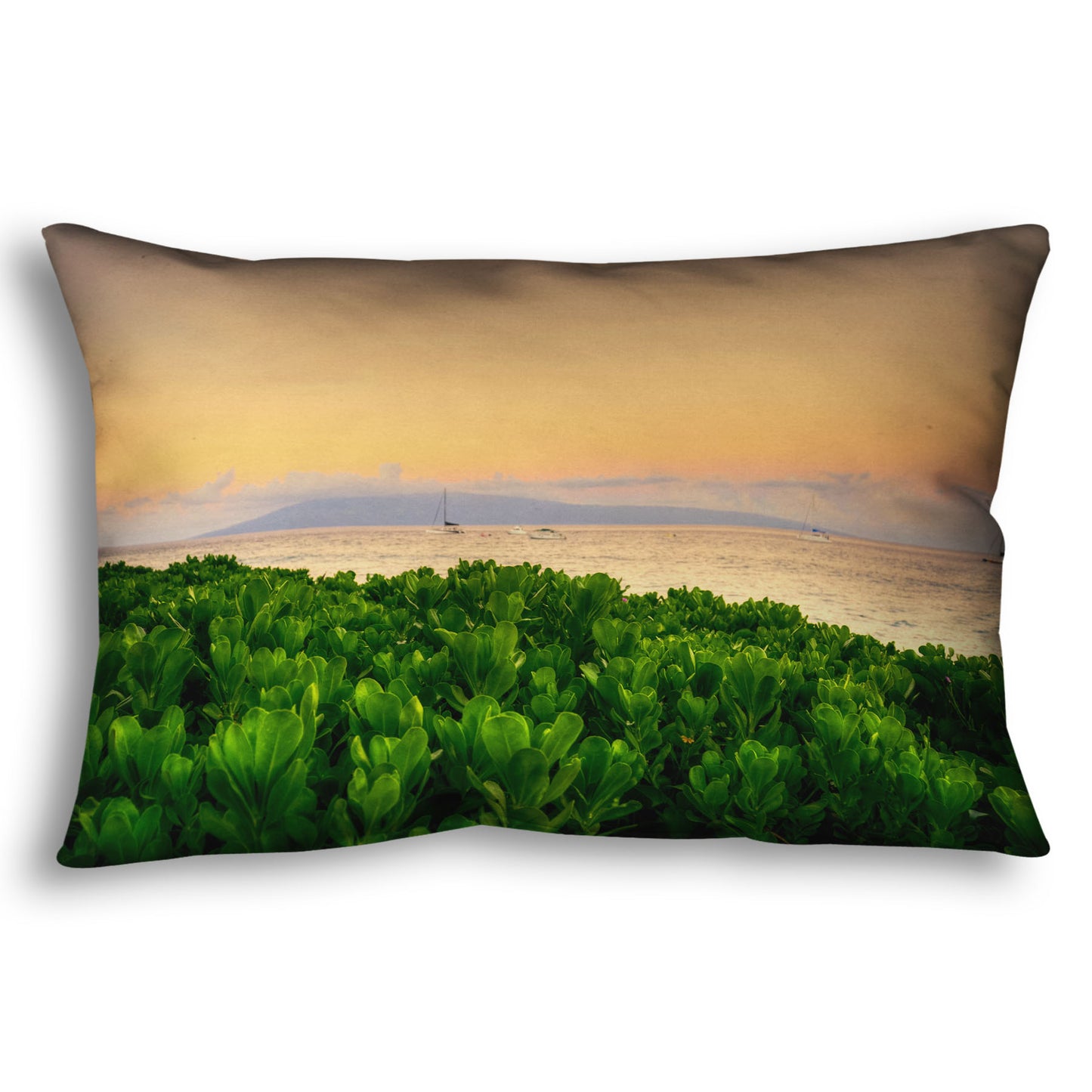 A throw pillow designed with a photo overlooking the sea from Kaanapali beach in Hawaii. Green plants fill the foreground, and boats sail on the water in the distance against a gentle orange sky and purple clouds. 