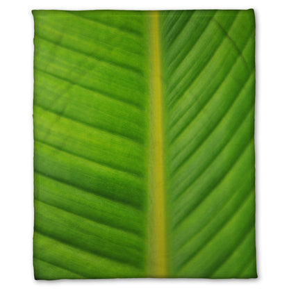 A fleece throw blanket designed with a closeup photo of a bird of paradise leaf, showing all the detail of the midrib and veins of the leaf.