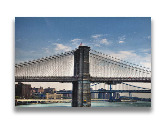 A photo of a side view of the Brooklyn Bridge against a blue sky. Printed on canvas.