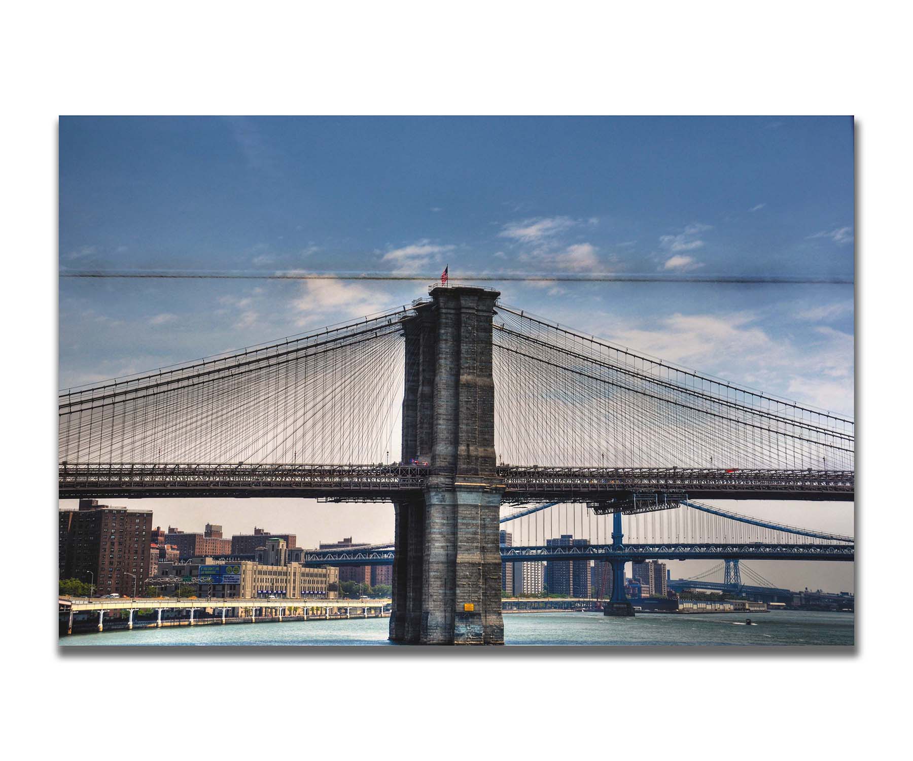 A photo of a side view of the Brooklyn Bridge against a blue sky. Printed on a box board.