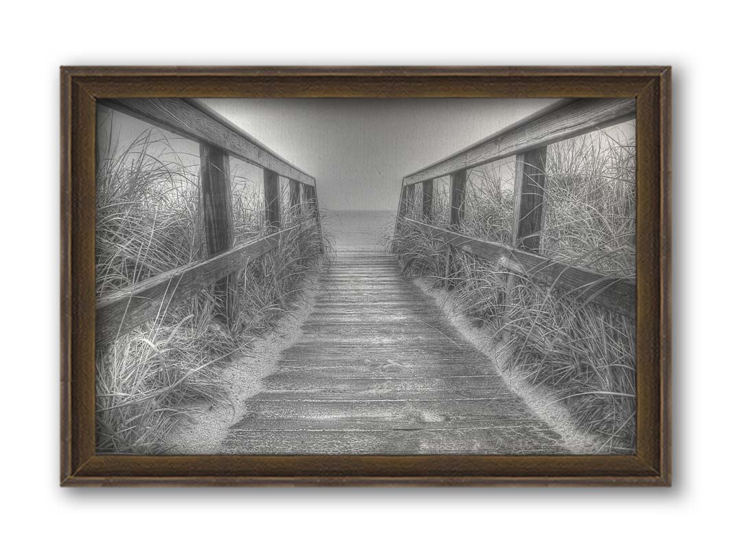 A grayscale photo looking down a wooden railed path on the beach at Cape Cod. Printed on canvas and framed.