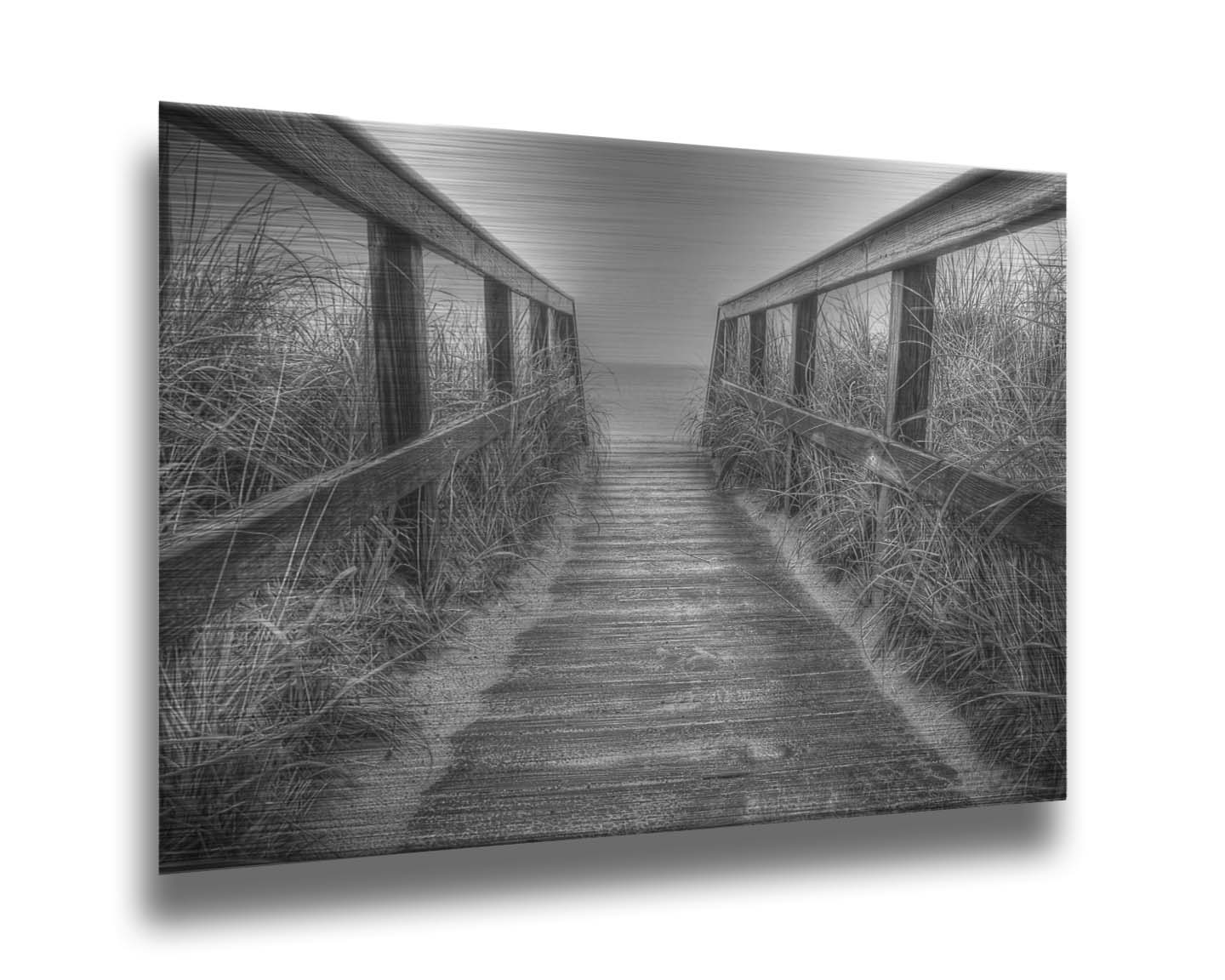 A grayscale photo looking down a wooden railed path on the beach at Cape Cod. Printed on metal.