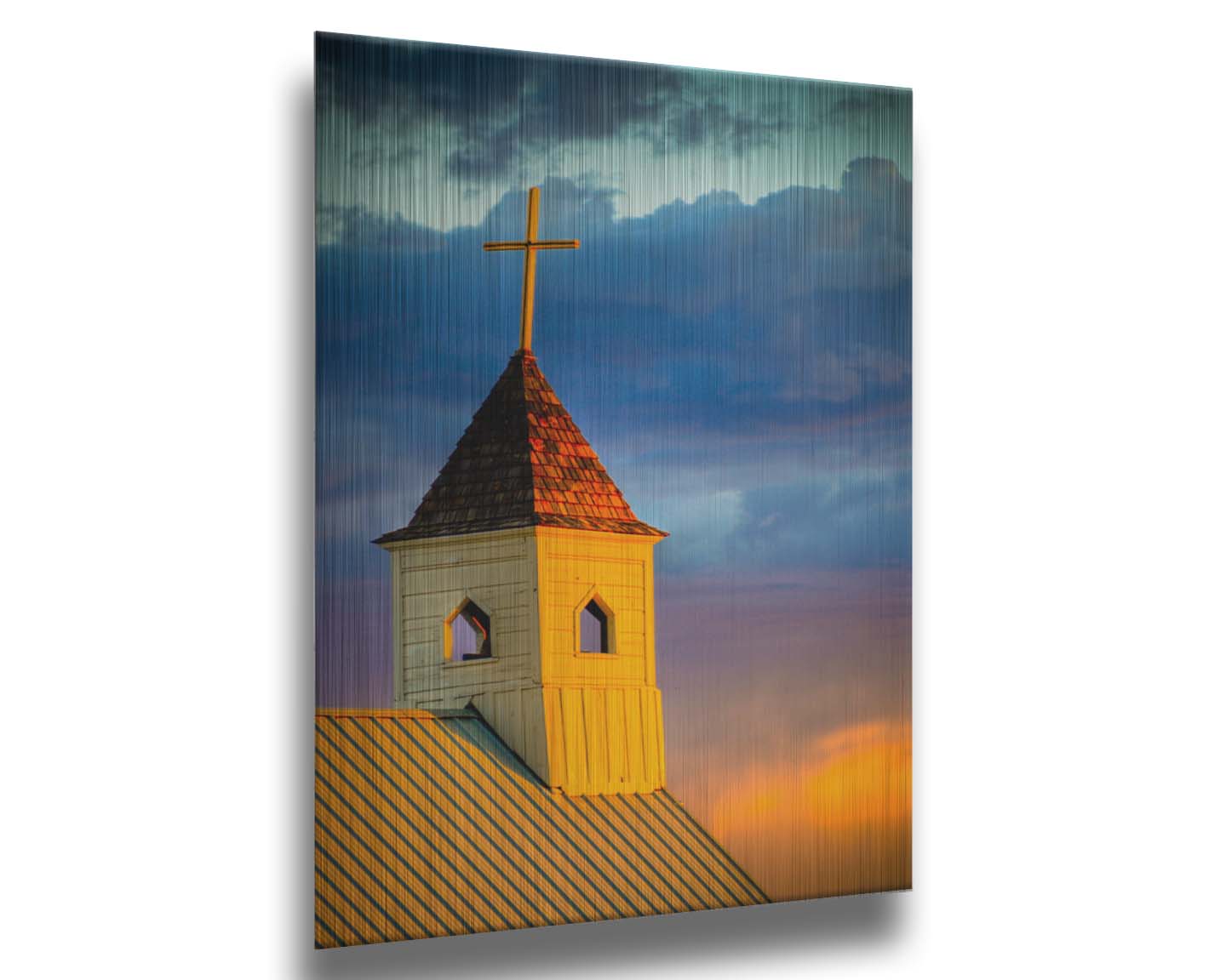 A photo of a cross-topped church at sunset, the sky gradiating from blue to purple to orange. Printed on metal.