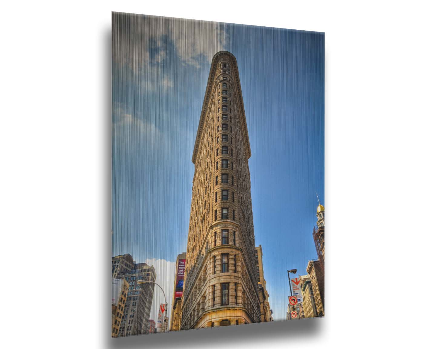 A photo of the Flatiron Building in New York City, New York. Its iconic triangular shape is captures against a bright blue sky. Printed on metal.