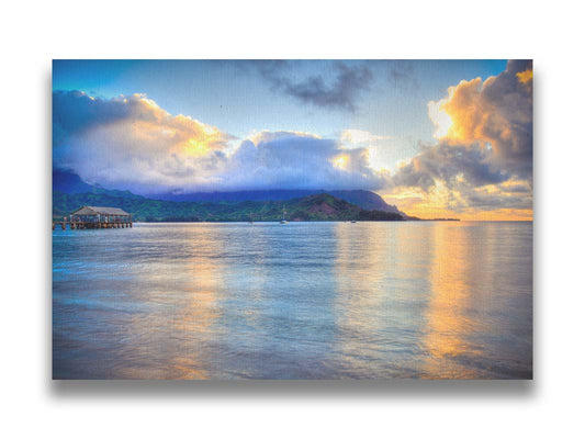 A photo of the ocean at Hanalei Bay at sunset. Clouds rest atop the mountains and reflect the golden light. Printed on canvas.