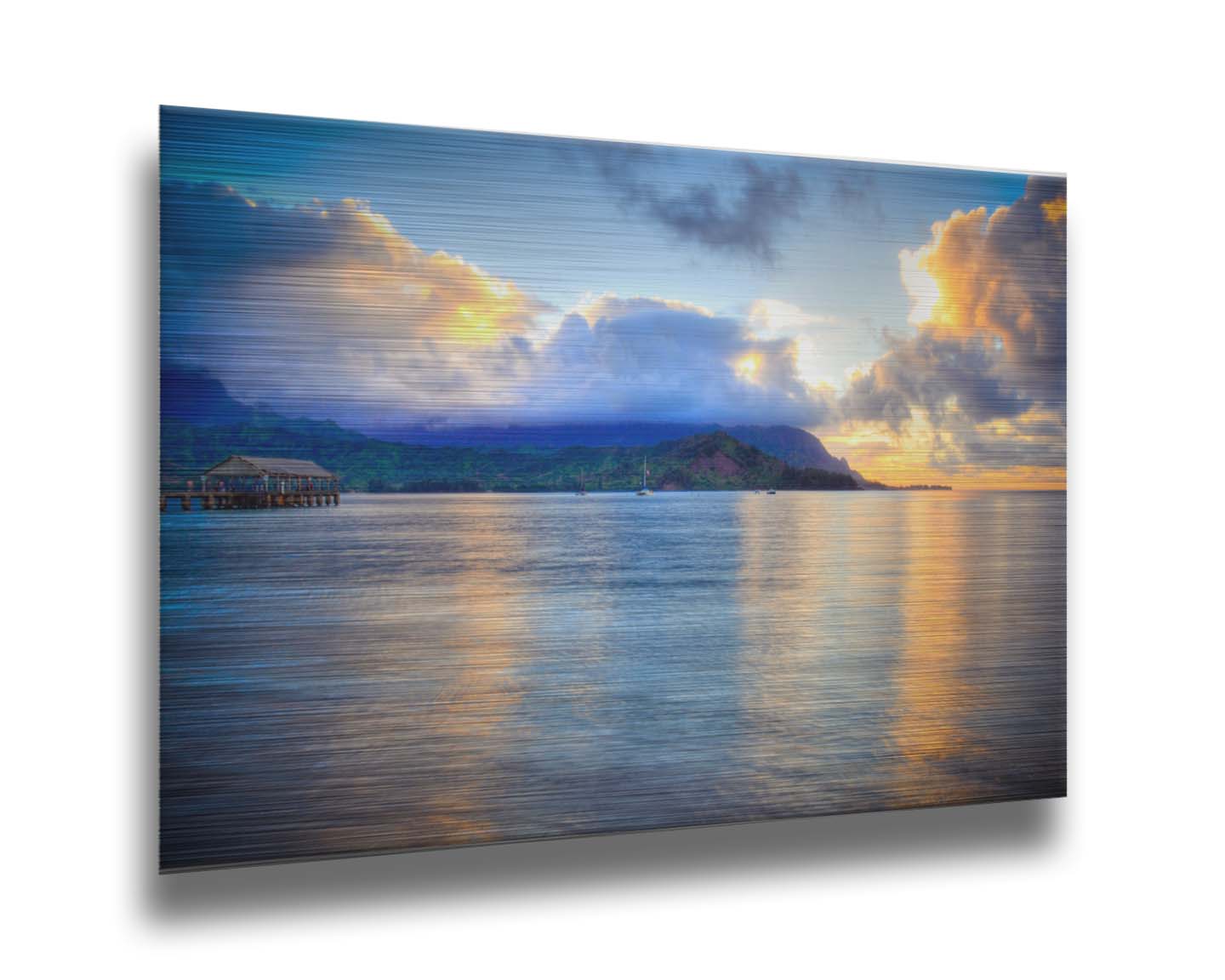 A photo of the ocean at Hanalei Bay at sunset. Clouds rest atop the mountains and reflect the golden light. Printed on metal.