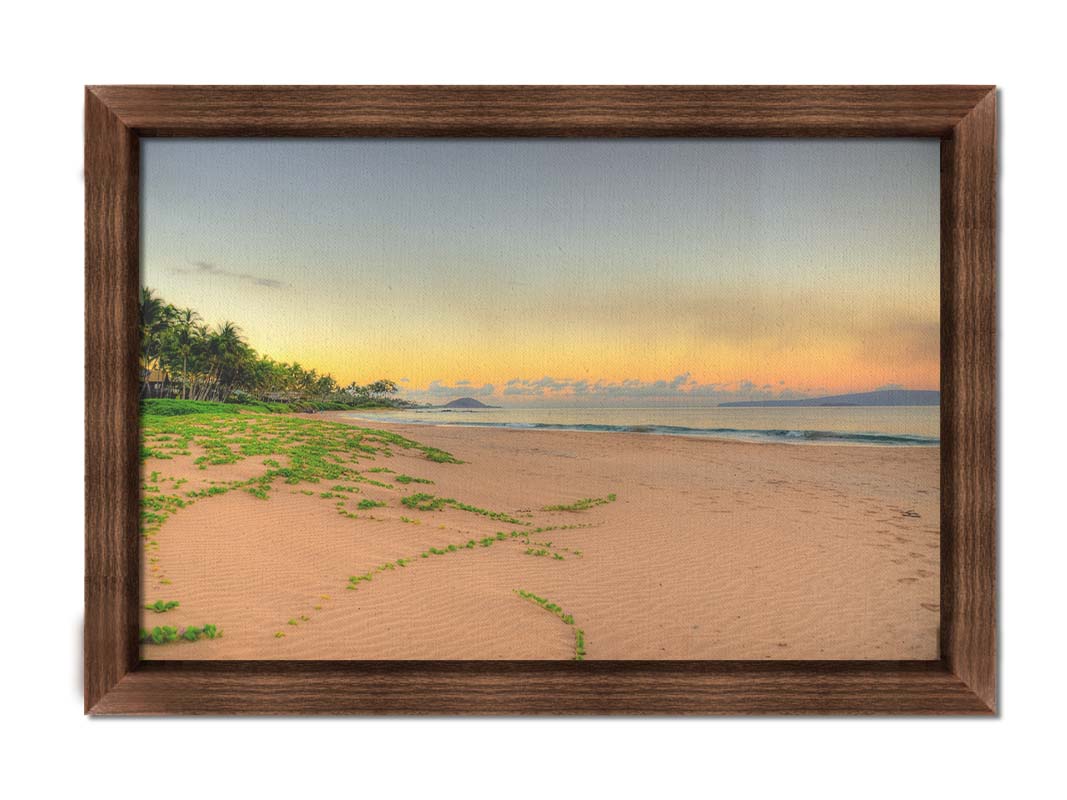 A photo of Keawakapu Beach at sunrise, with palms and mountains in the distance. Printed on canvas and framed.