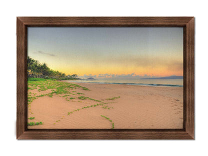 A photo of Keawakapu Beach at sunrise, with palms and mountains in the distance. Printed on canvas and framed.