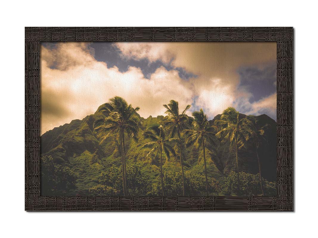 A photo of a line of palm trees in the wind, backed by the Koʻolau mountain range. Printed on canvas and framed.