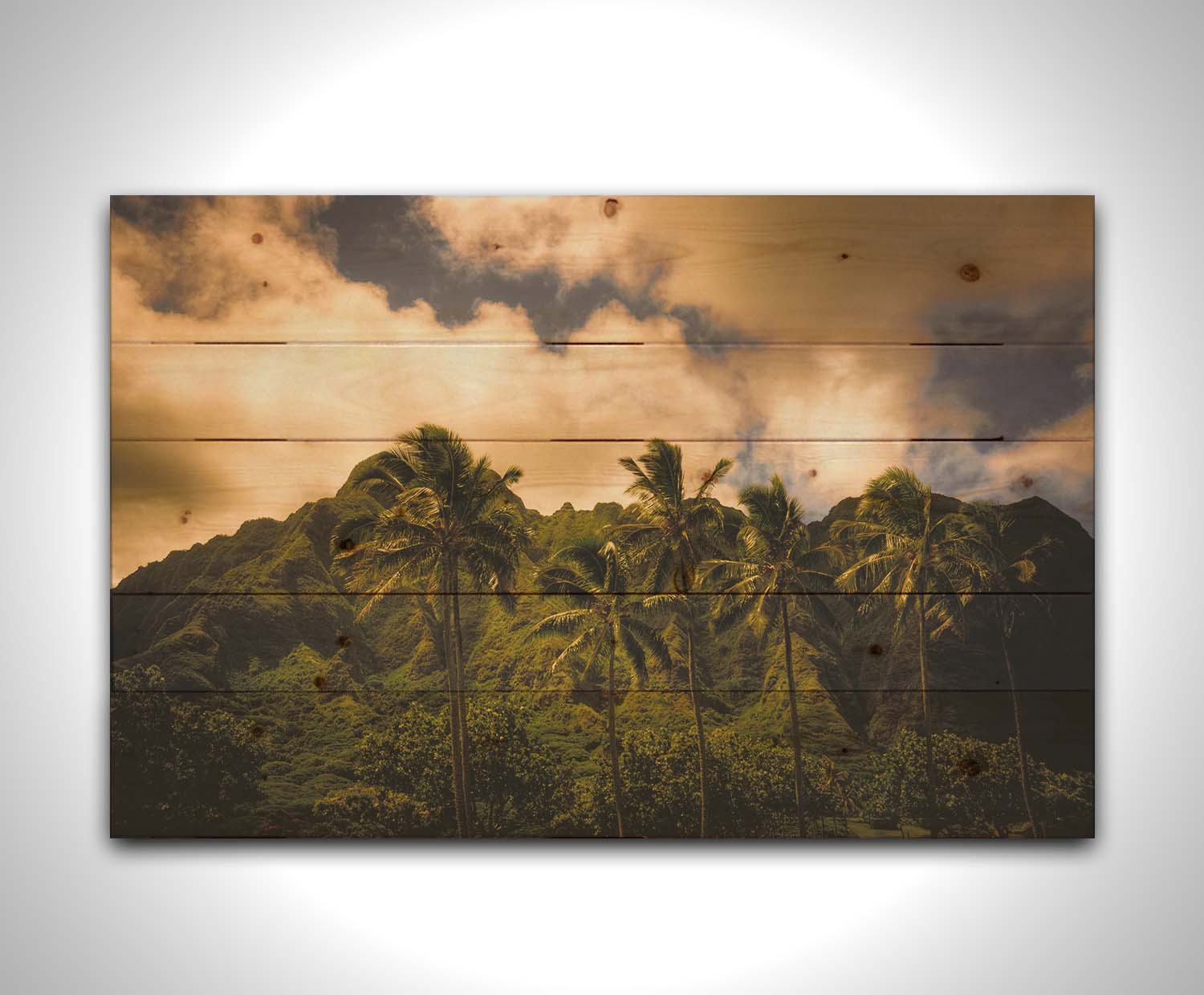 A photo of a line of palm trees in the wind, backed by the Koʻolau mountain range. Printed on a wood pallet.