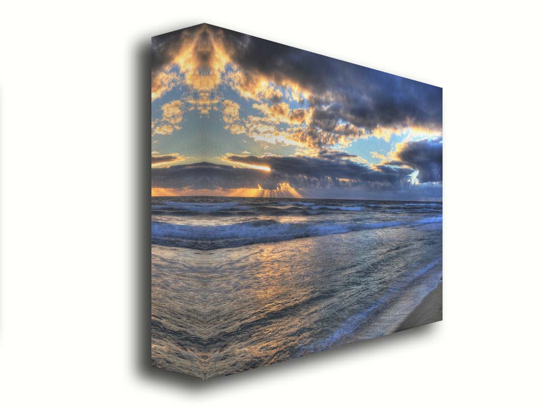 A photo looking out to sea off the coast of Kauaʻi at sunrise. The sunlight reflects off the sea and clouds in a beautiful parallel. Printed on canvas.