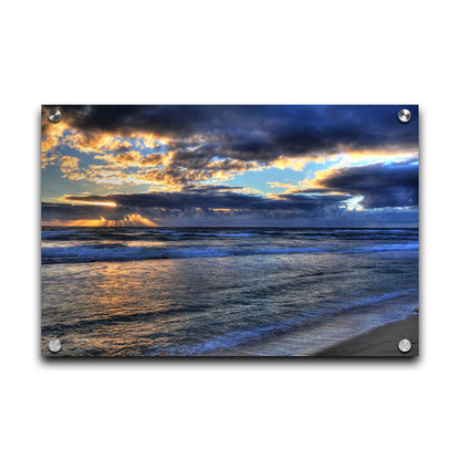 A photo looking out to sea off the coast of Kauaʻi at sunrise. The sunlight reflects off the sea and clouds in a beautiful parallel. Printed on acrylic.