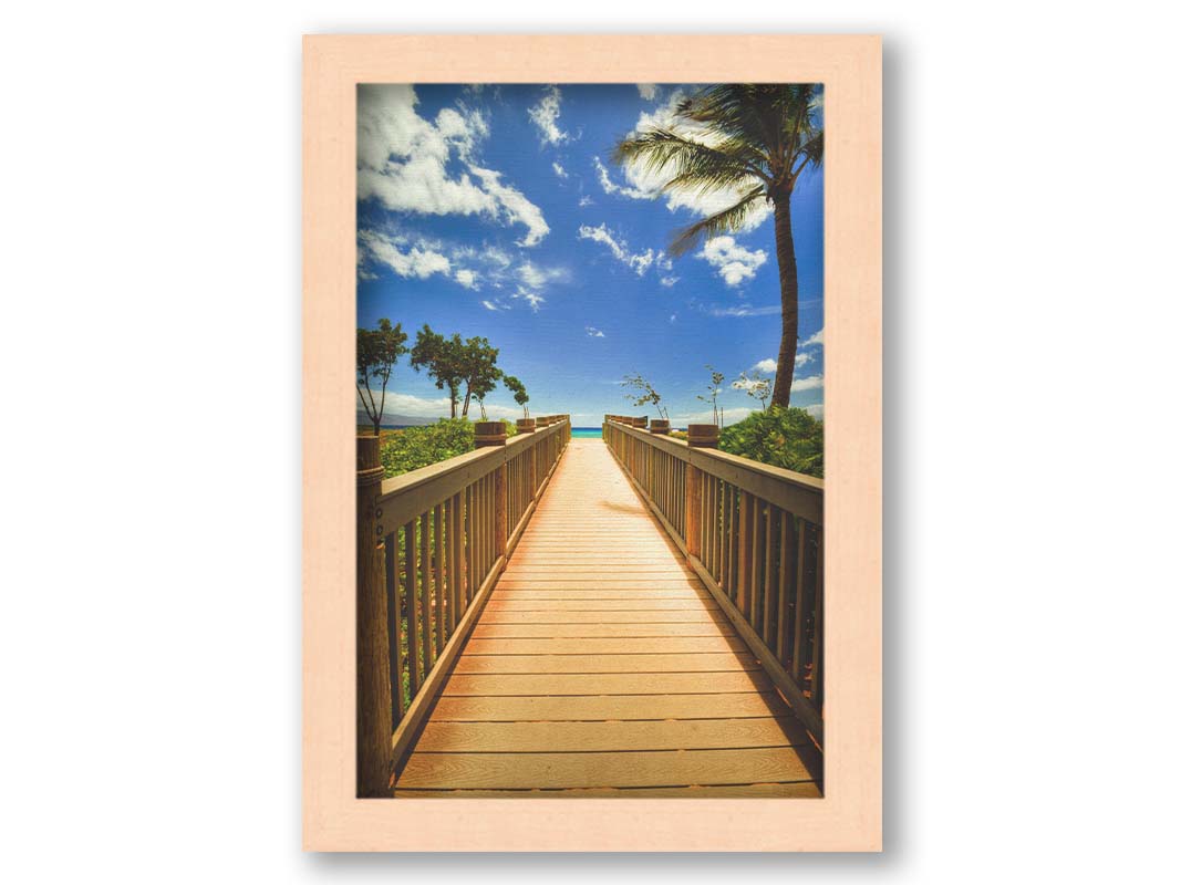 A photo of a boardwalk in Maui, Hawaiʻi, looking down the wood path to the sea. It is flanked by shrubbery, palms, and other tropical trees. Printed on canvas and framed.