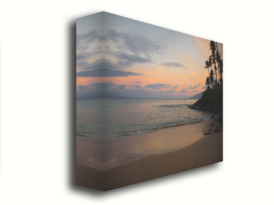 A photo looking out to sea at Maui during sunrise. A surfer can be seen on the water in the distance. Printed on canvas.