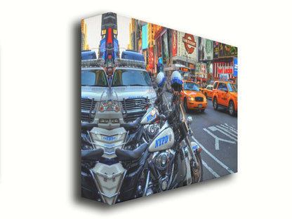 A photo of a street in New York City, featuring several bright orange taxis and New York Police Department vehicles. Printed on canvas.