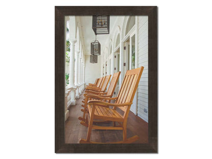 A photo looking down a row of rocking chairs on a porch in O'ahu, Hawaiʻi. Printed on canvas and framed.